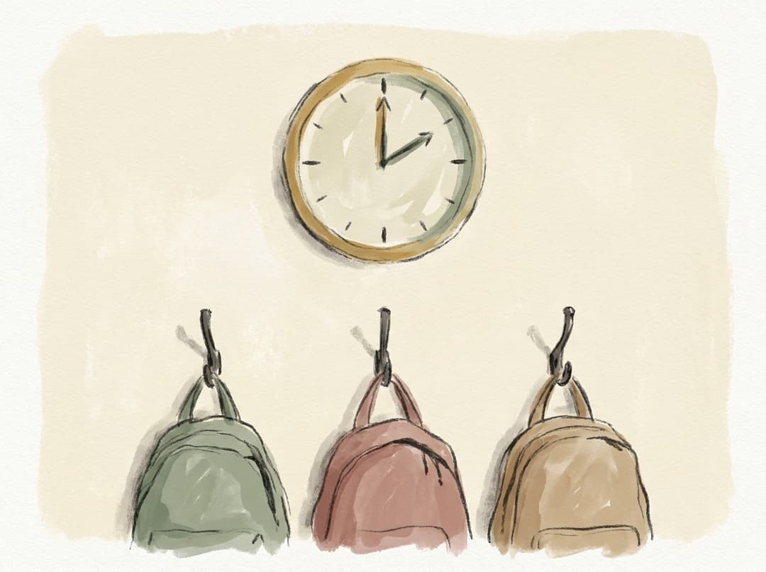 Eine Klassenraum-Wanduhr über einer Reihe Garderobenhaken mit drei unterschiedlichen Schultaschen